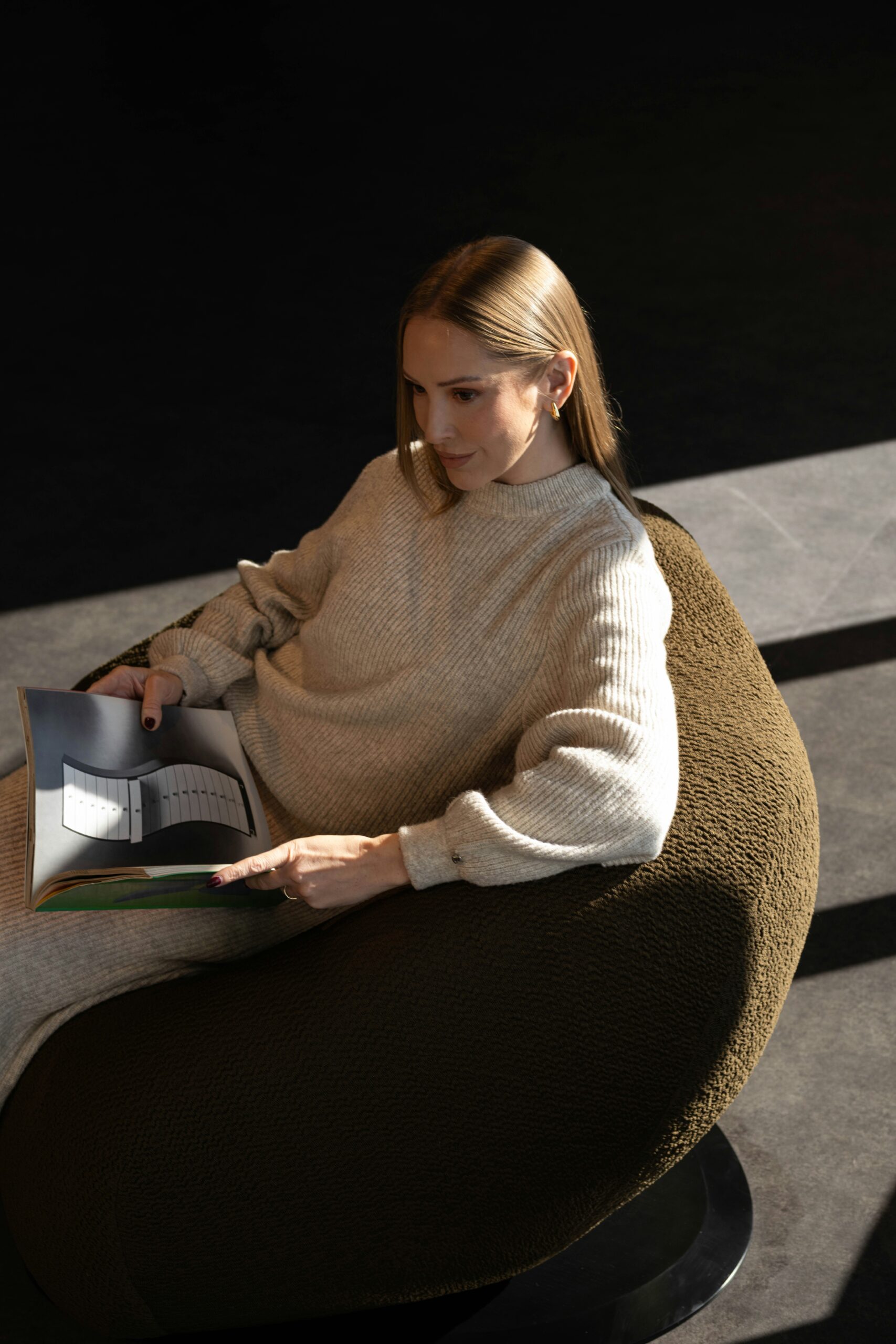 alt="ソファに座って家具の雑誌を広げる女性"